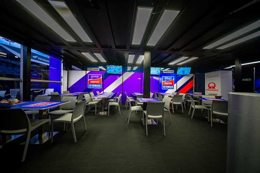 Sala dell'hospitality Pramac Racing con tavoli e schermi